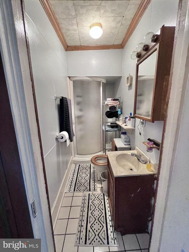 bathroom with tile flooring, walk in shower, vanity, and crown molding