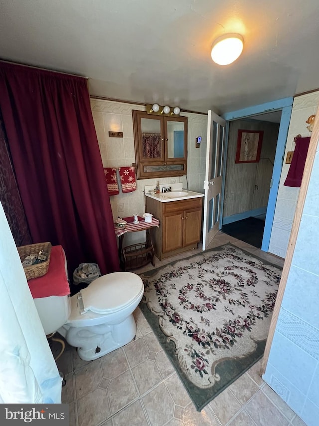 bathroom with tile floors, toilet, and vanity