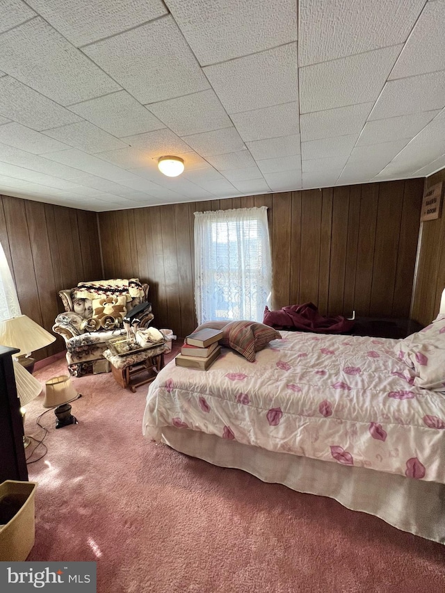 carpeted bedroom with wood walls