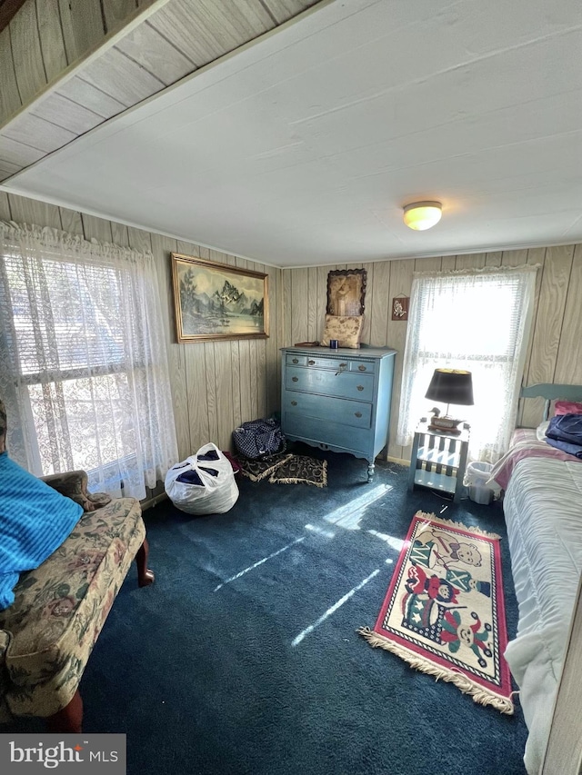 carpeted living room featuring wooden walls