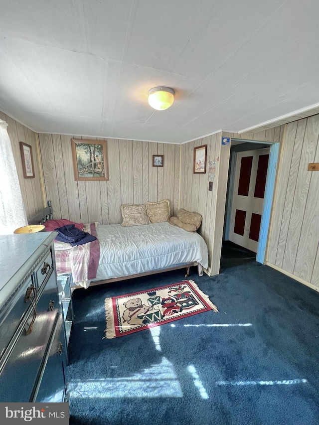 carpeted bedroom featuring wood walls