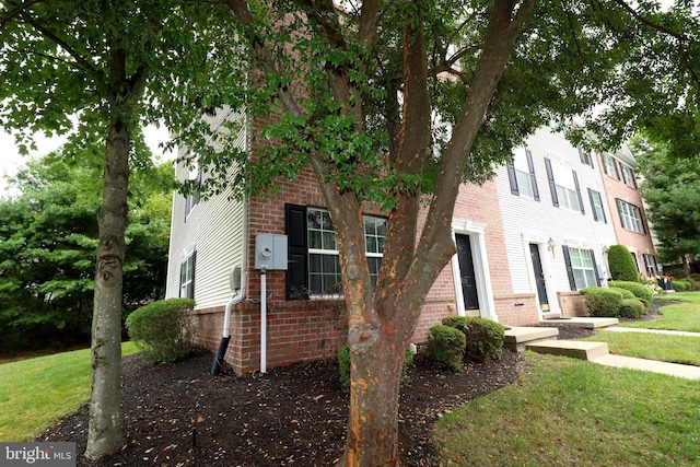 townhome / multi-family property featuring brick siding and a front lawn