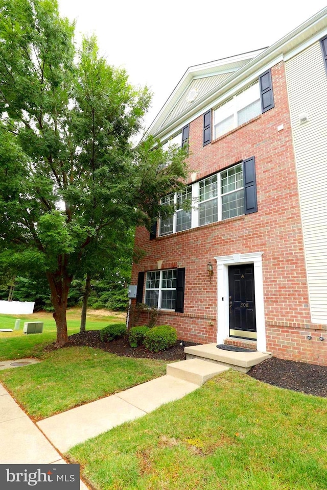 view of front facade with a front lawn and brick siding