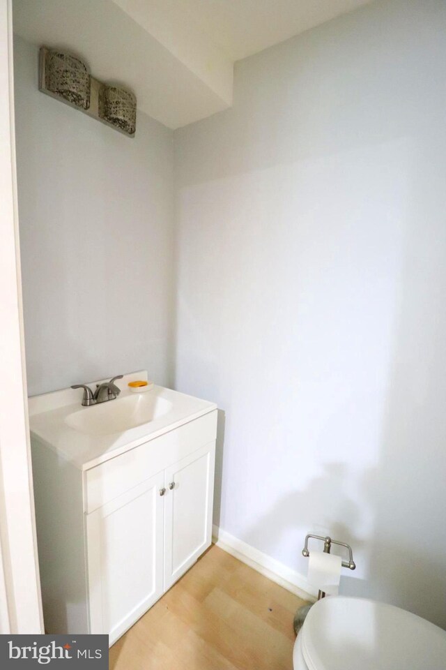 bathroom with vanity, toilet, and wood-type flooring