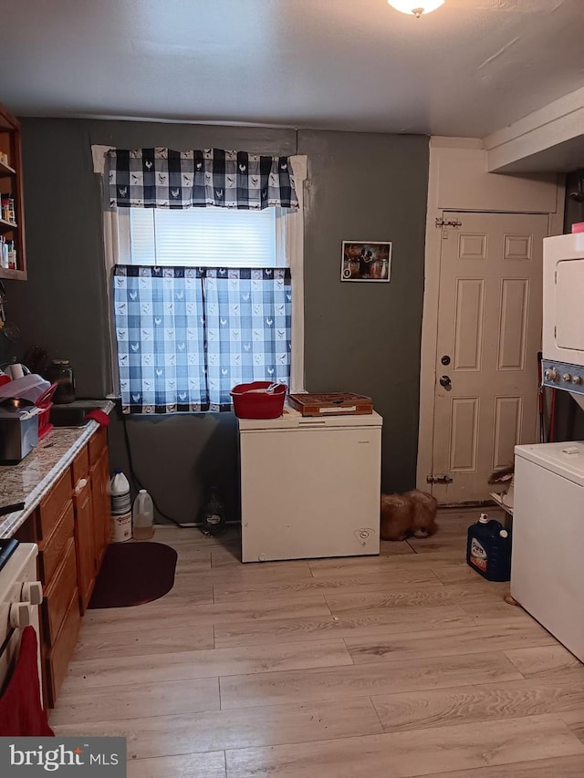 dining area with stacked washer and clothes dryer and light hardwood / wood-style floors