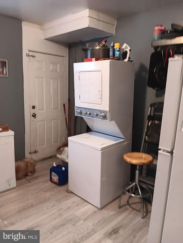 washroom featuring light wood-type flooring and stacked washer and clothes dryer