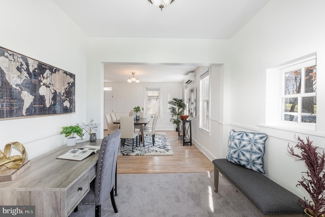 dining room featuring a wall unit AC and light hardwood / wood-style flooring