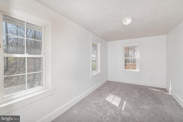 unfurnished room with dark colored carpet