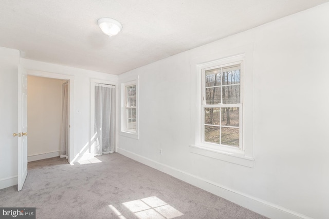 unfurnished bedroom with light colored carpet and multiple windows