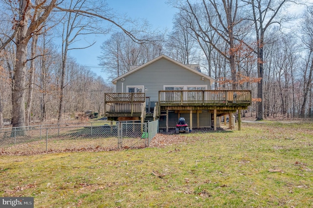 rear view of house with a wooden deck and a yard