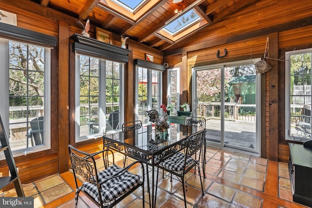 sunroom / solarium featuring vaulted ceiling with skylight, wooden ceiling, and a wealth of natural light