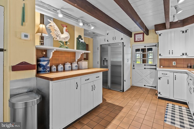 kitchen featuring backsplash, beamed ceiling, white cabinetry, and high end refrigerator