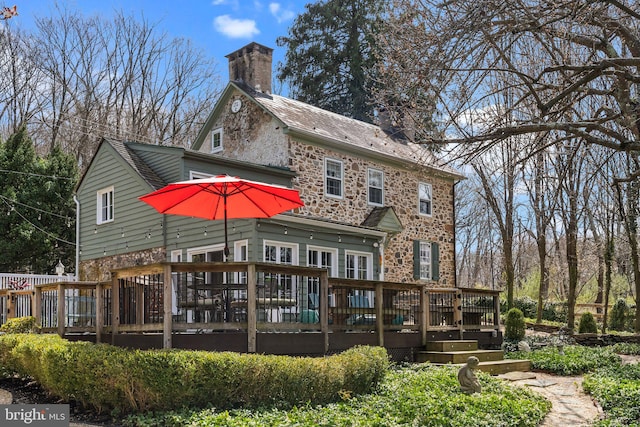 rear view of house featuring a wooden deck