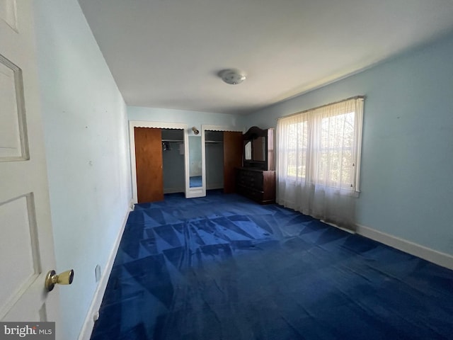 unfurnished bedroom featuring dark colored carpet