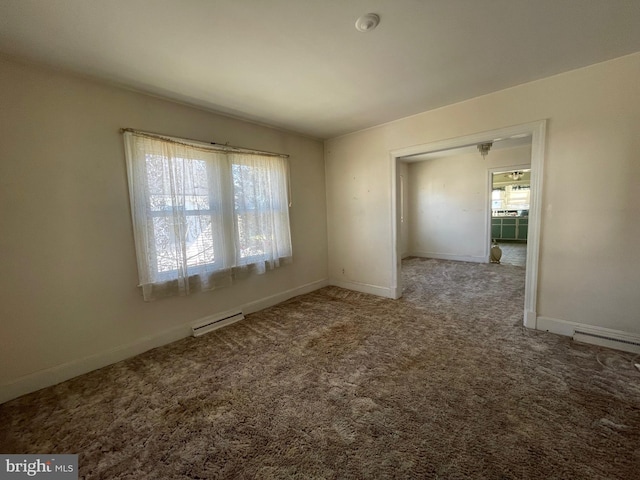 carpeted spare room with a baseboard radiator