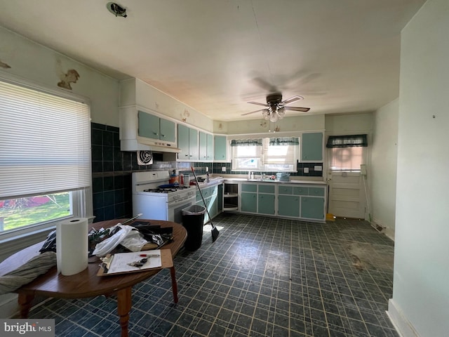 kitchen featuring decorative backsplash, white cabinetry, white range with gas stovetop, ceiling fan, and green cabinets