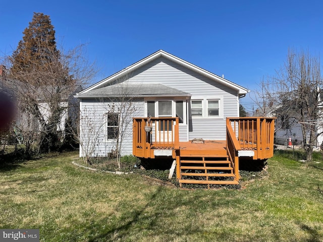 back of house featuring a wooden deck and a lawn