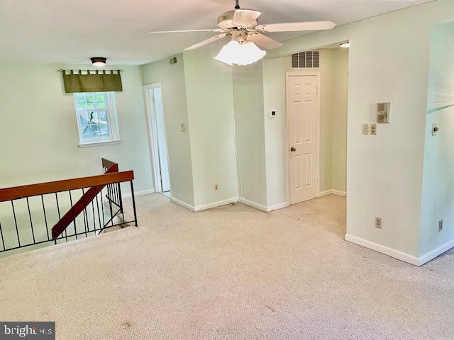 carpeted spare room with ceiling fan