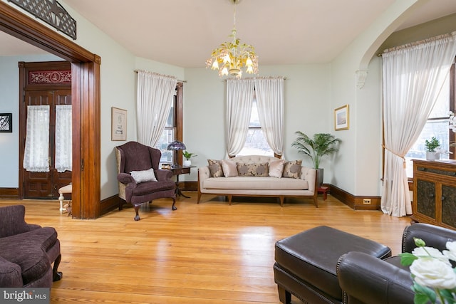 living room featuring a chandelier and light wood-type flooring