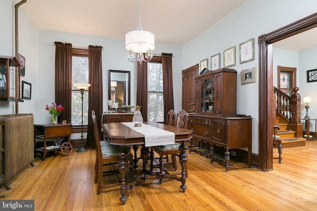 dining space with a notable chandelier and light hardwood / wood-style flooring