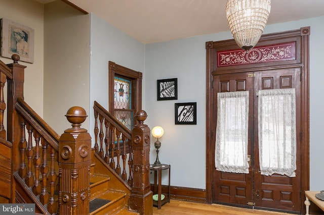 foyer featuring hardwood / wood-style flooring, french doors, and a notable chandelier