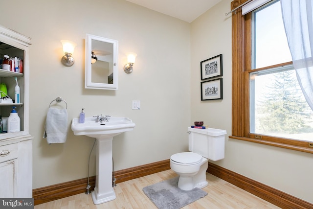 bathroom with toilet, sink, and hardwood / wood-style floors