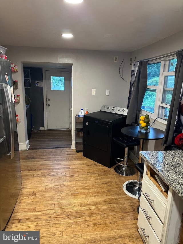 laundry area with washer / clothes dryer and light hardwood / wood-style flooring