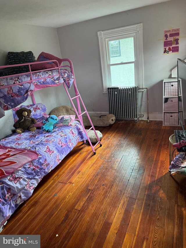 bedroom featuring wood-type flooring and radiator