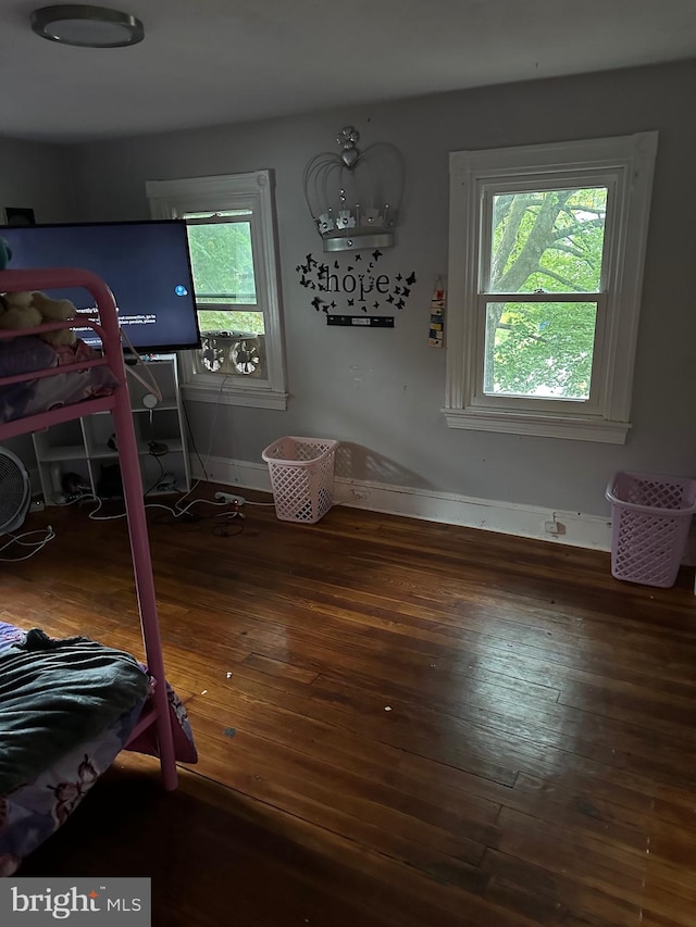 bedroom featuring a notable chandelier, dark hardwood / wood-style flooring, and multiple windows