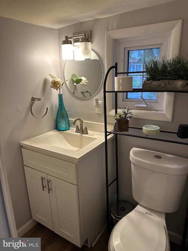 bathroom featuring hardwood / wood-style flooring, vanity, and toilet