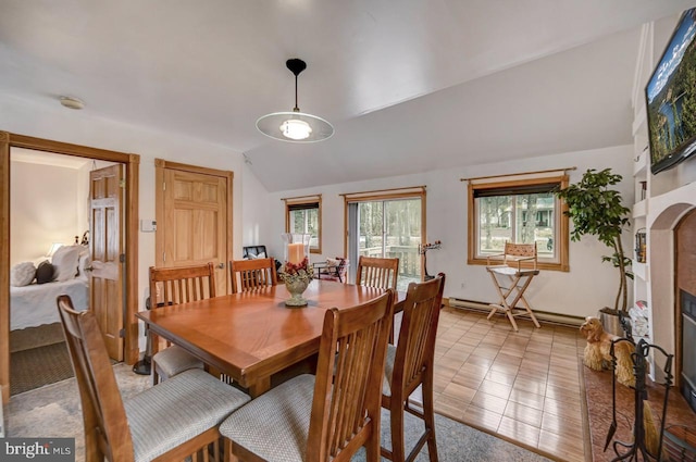 dining space with vaulted ceiling, light tile floors, and a baseboard heating unit