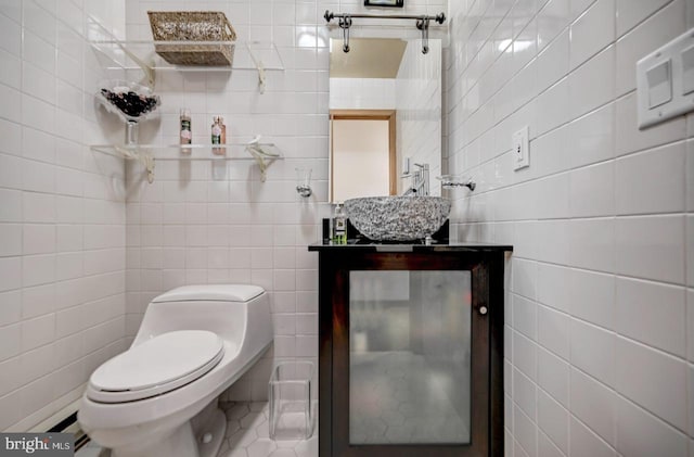 bathroom featuring tile walls, toilet, tile floors, and sink