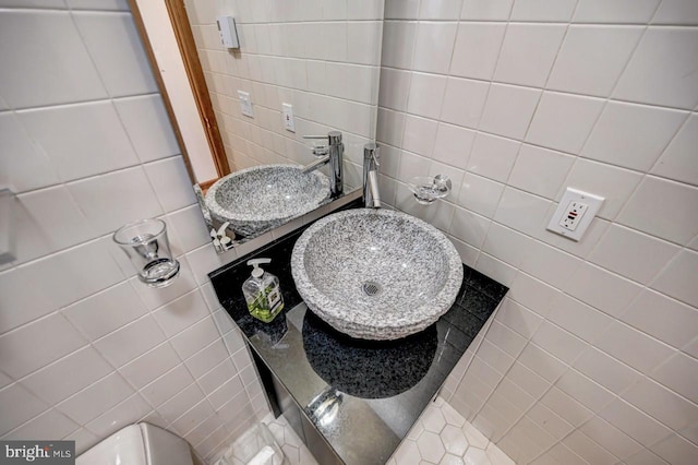 bathroom with tile walls, sink, and toilet