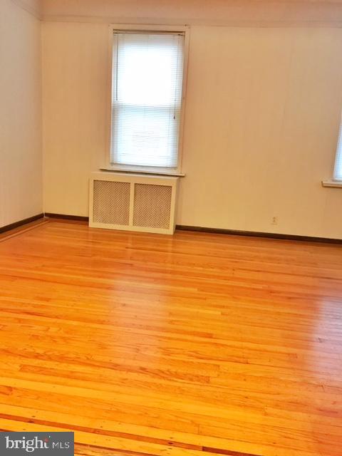 spare room with light hardwood / wood-style flooring and radiator