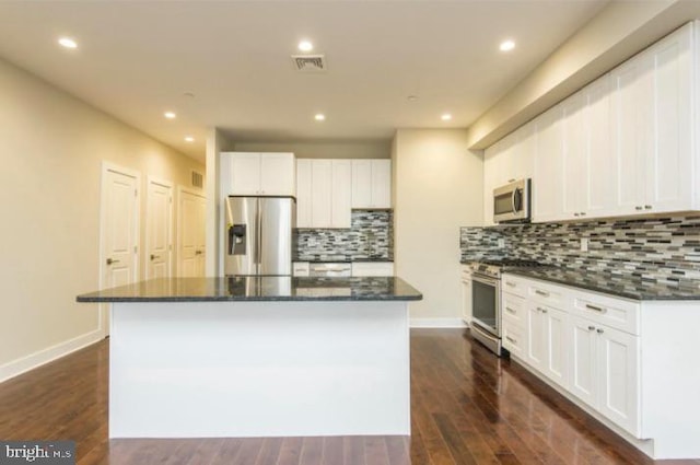 kitchen with a center island, dark hardwood / wood-style floors, tasteful backsplash, and stainless steel appliances