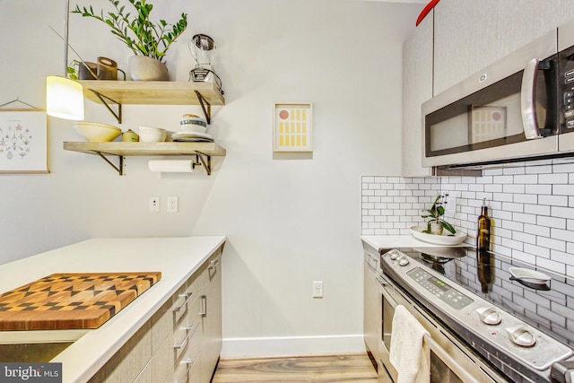 kitchen featuring backsplash, light wood-type flooring, and range with electric stovetop