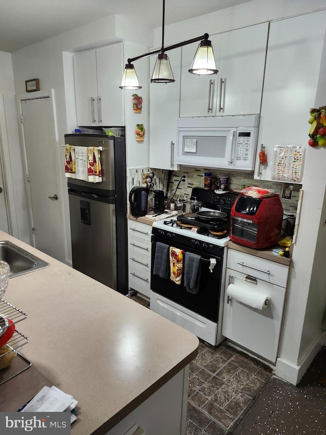 kitchen with backsplash, hanging light fixtures, white cabinets, sink, and white appliances