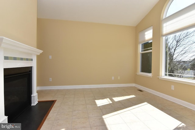 unfurnished living room with light tile flooring and vaulted ceiling