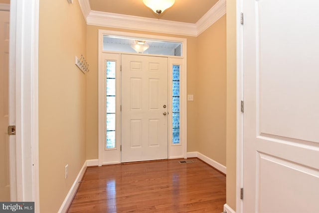 foyer with dark hardwood / wood-style flooring, crown molding, and a wealth of natural light