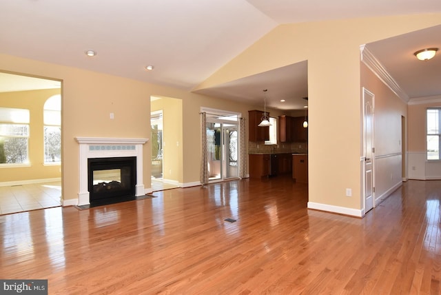 unfurnished living room featuring plenty of natural light, wood-type flooring, and a multi sided fireplace