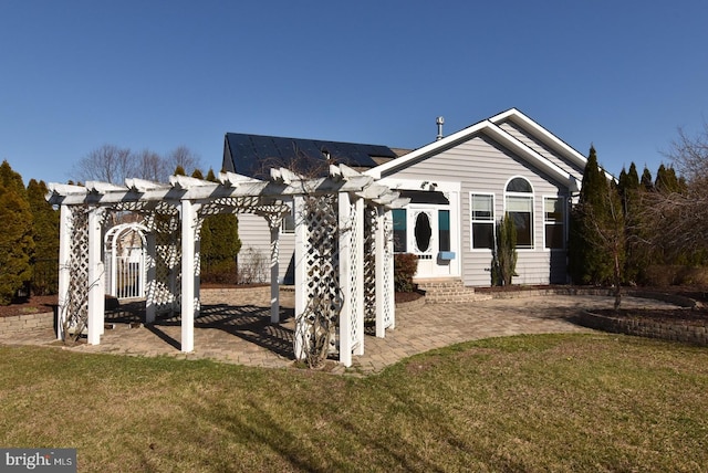 rear view of house featuring a lawn, a pergola, and a patio area