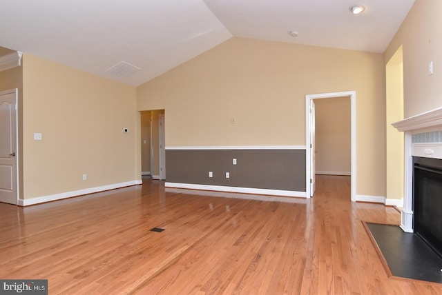 unfurnished living room featuring high vaulted ceiling and light hardwood / wood-style floors