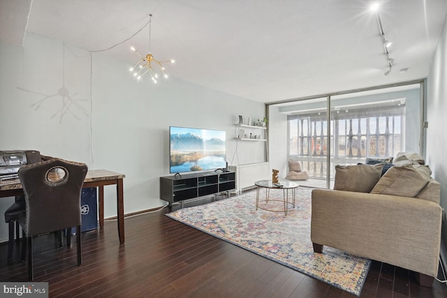 living room with rail lighting, dark hardwood / wood-style floors, and a notable chandelier