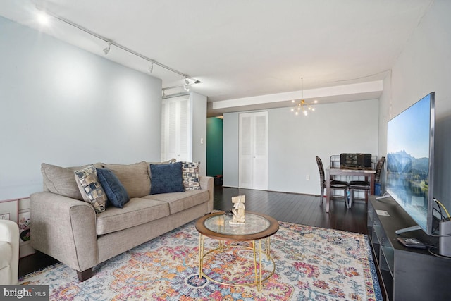 living room featuring a chandelier, dark hardwood / wood-style flooring, and track lighting