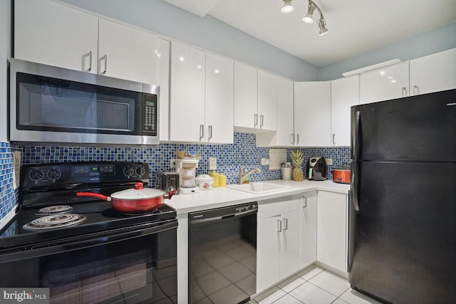 kitchen with backsplash, light tile flooring, black appliances, white cabinetry, and sink