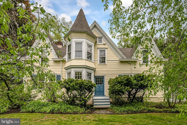 victorian-style house with a front lawn