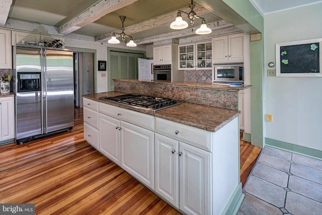 kitchen with backsplash, hanging light fixtures, stainless steel appliances, white cabinets, and beamed ceiling