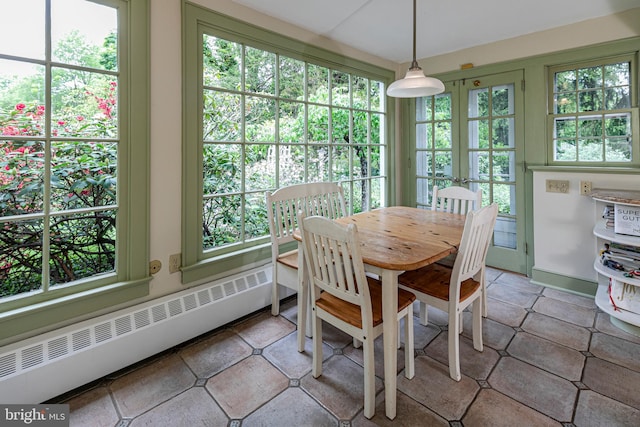 dining space with plenty of natural light, a baseboard heating unit, and tile floors