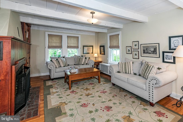 living room featuring beamed ceiling, hardwood / wood-style floors, and a wealth of natural light