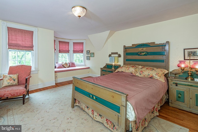 bedroom featuring hardwood / wood-style floors and multiple windows